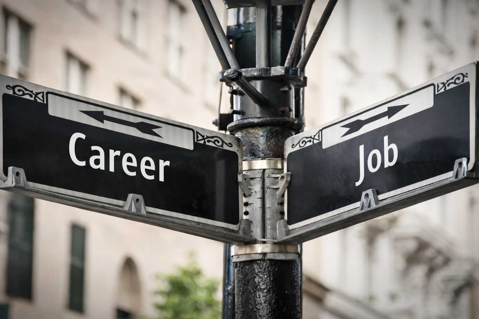 A street signpost with arrows labeled “Career” and “Job,” symbolizing choosing a meaningful path and professional growth.